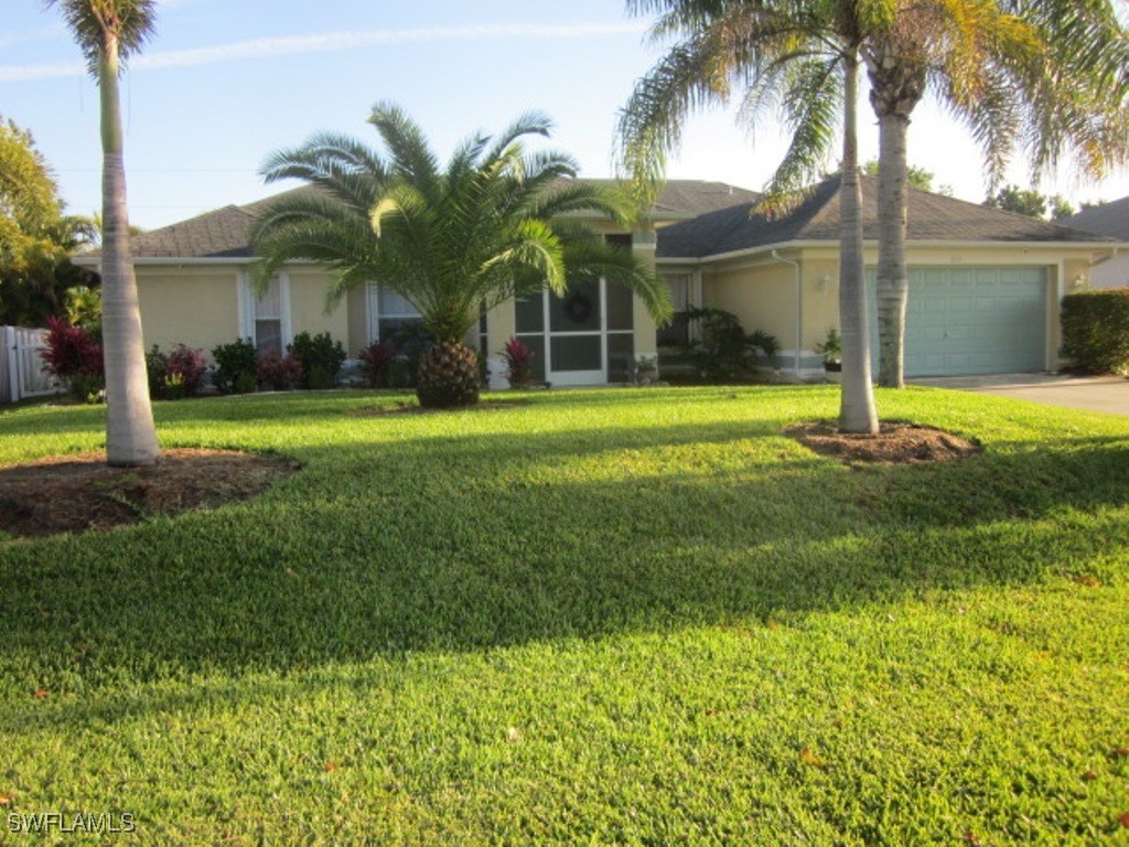 a view of a white house with a big yard and potted plants