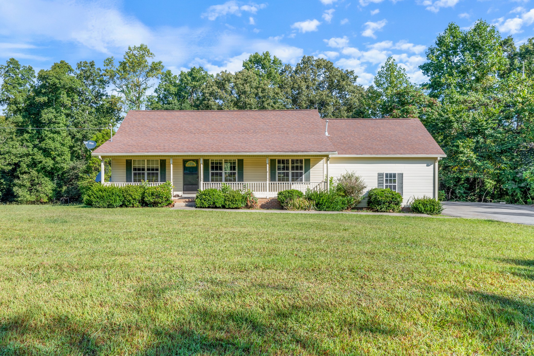 a front view of a house with a yard and trees