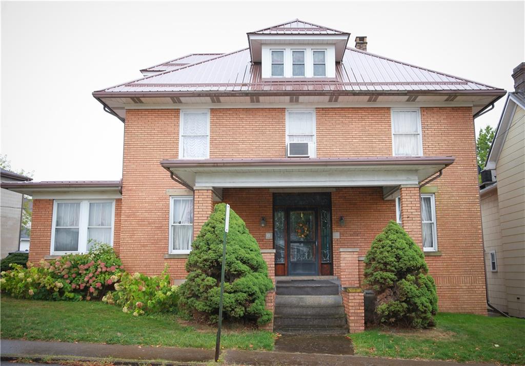 a front view of a house with plants