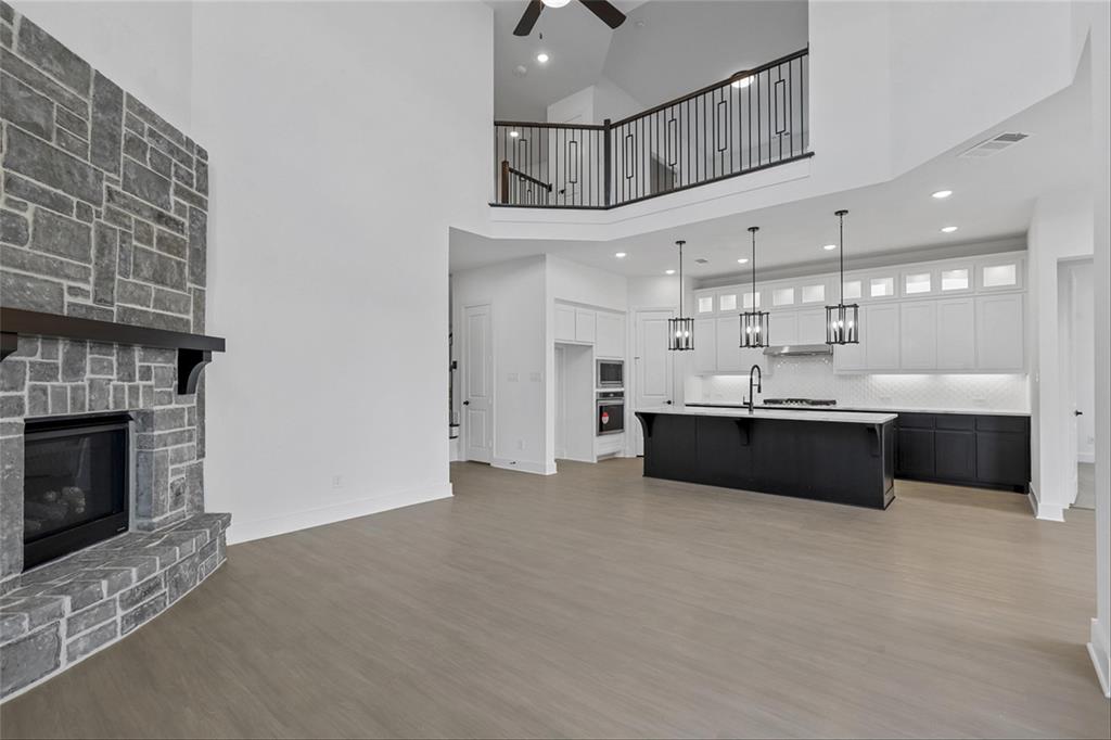 a large white kitchen with a sink stainless steel appliances and a chandelier