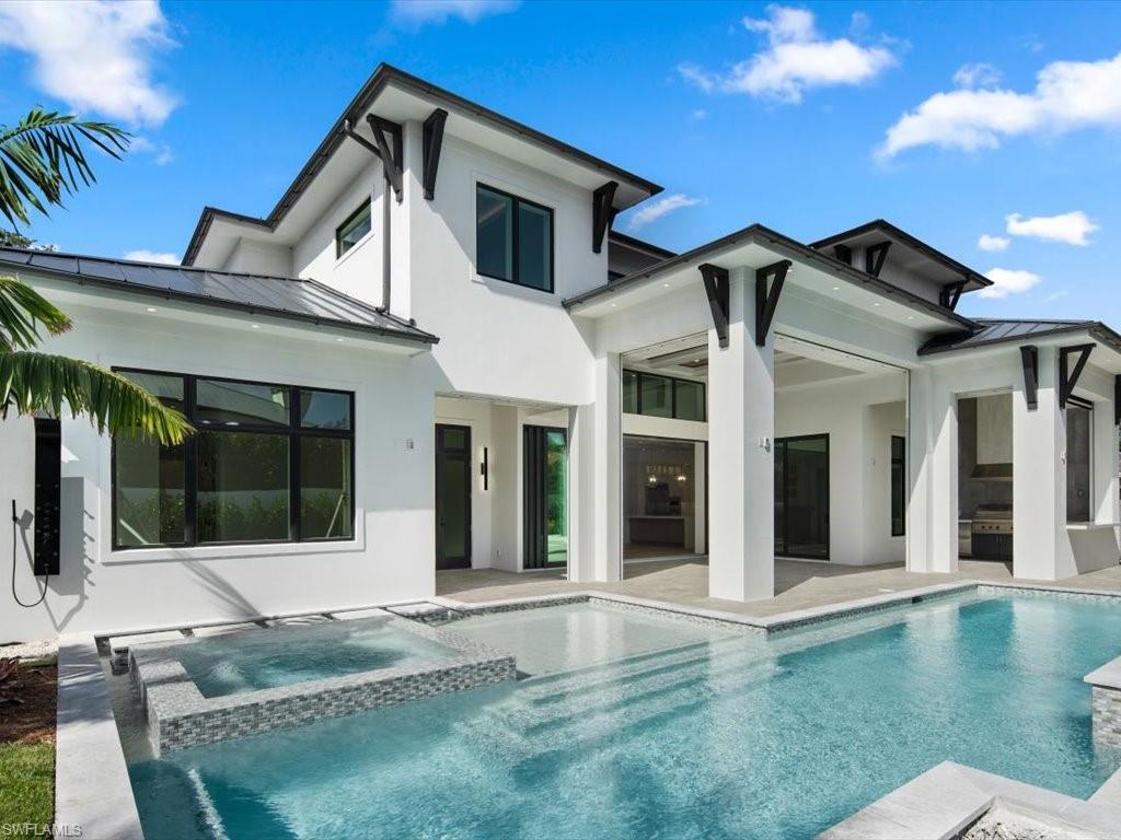 Rear view of property with a swimming pool with hot tub and a patio area