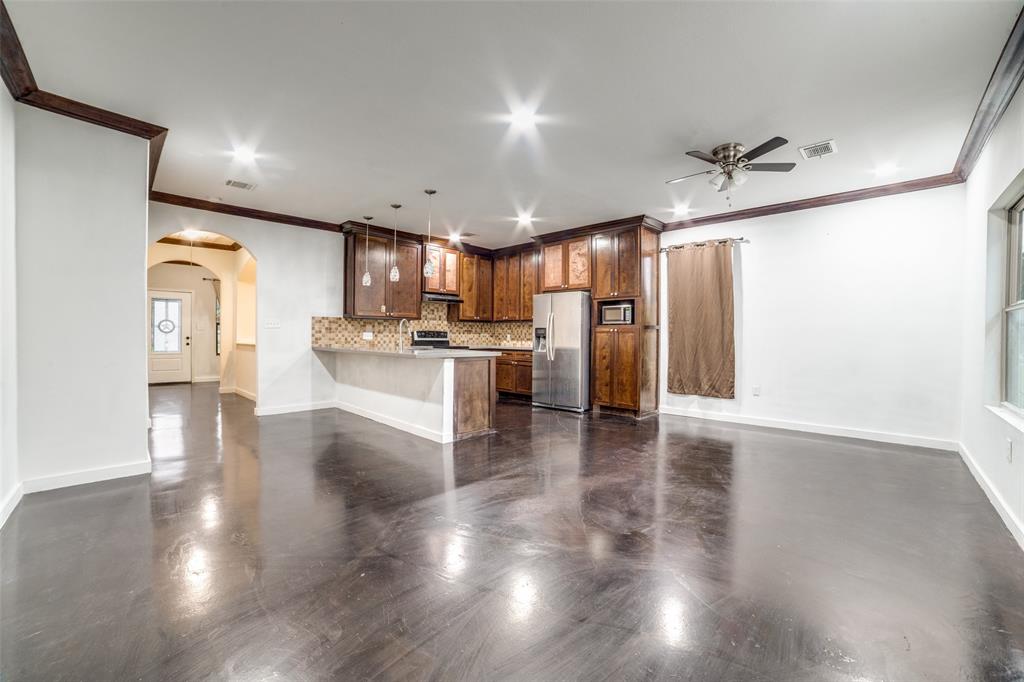 a kitchen with stainless steel appliances granite countertop a refrigerator microwave and wooden floor