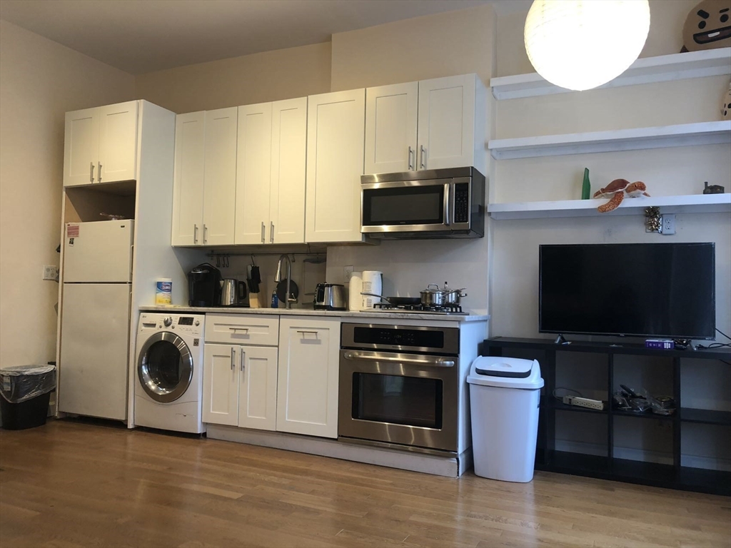 a kitchen with stainless steel appliances a stove a sink and a microwave