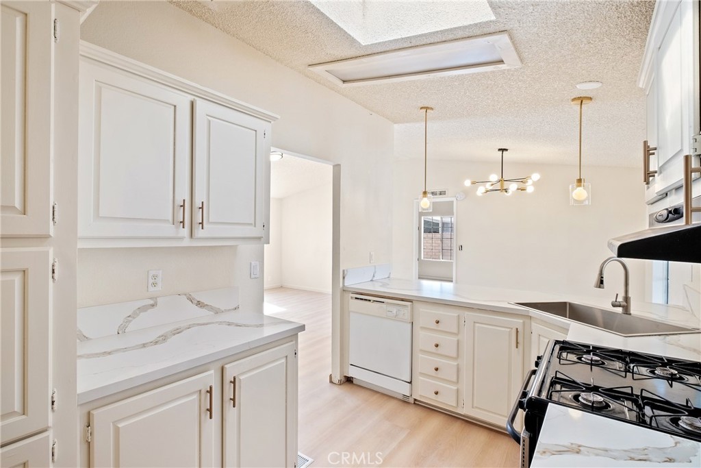 a kitchen with a sink cabinets and wooden floor