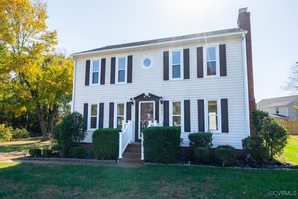 Colonial inspired home featuring a front yard