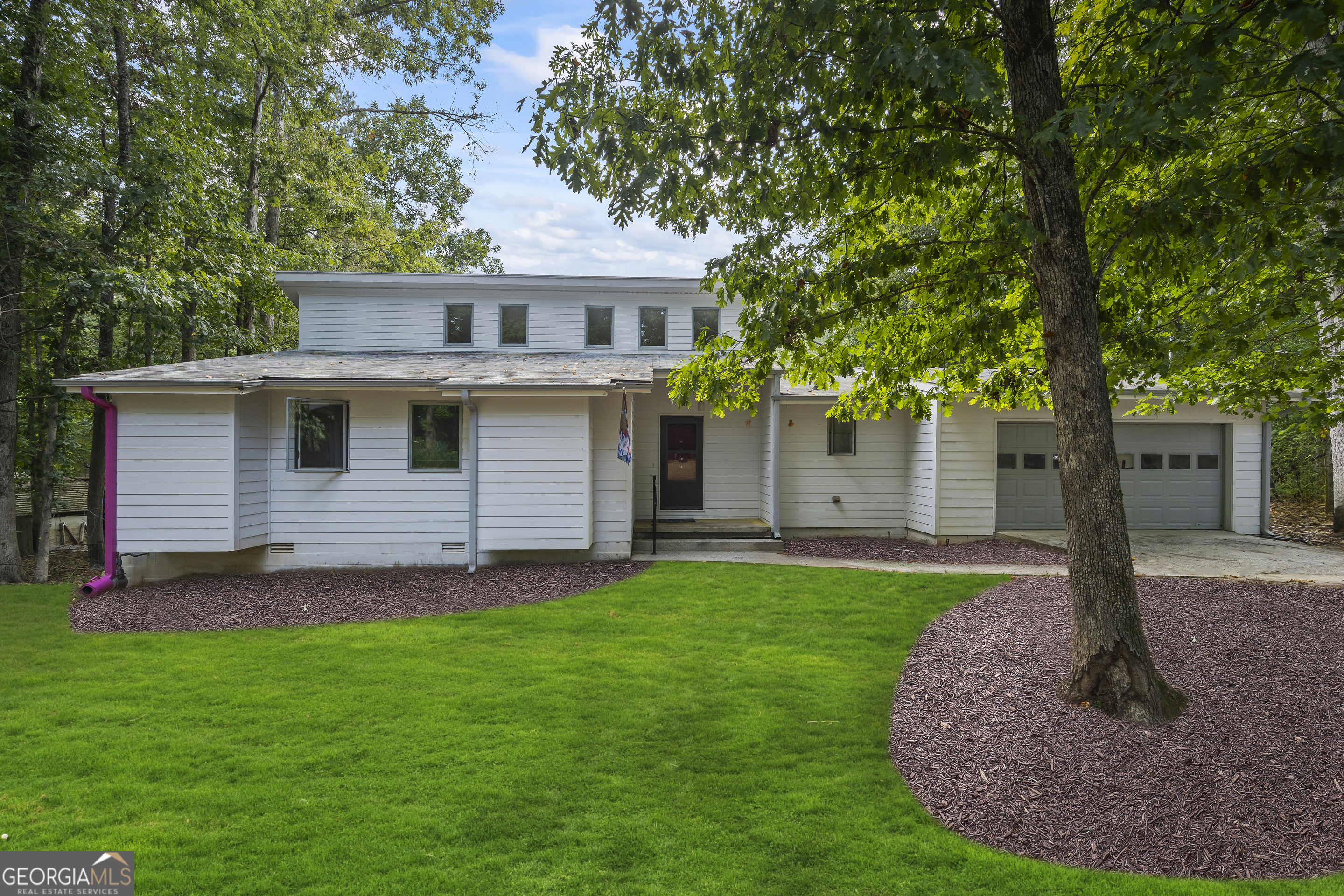 a front view of house with yard and green space