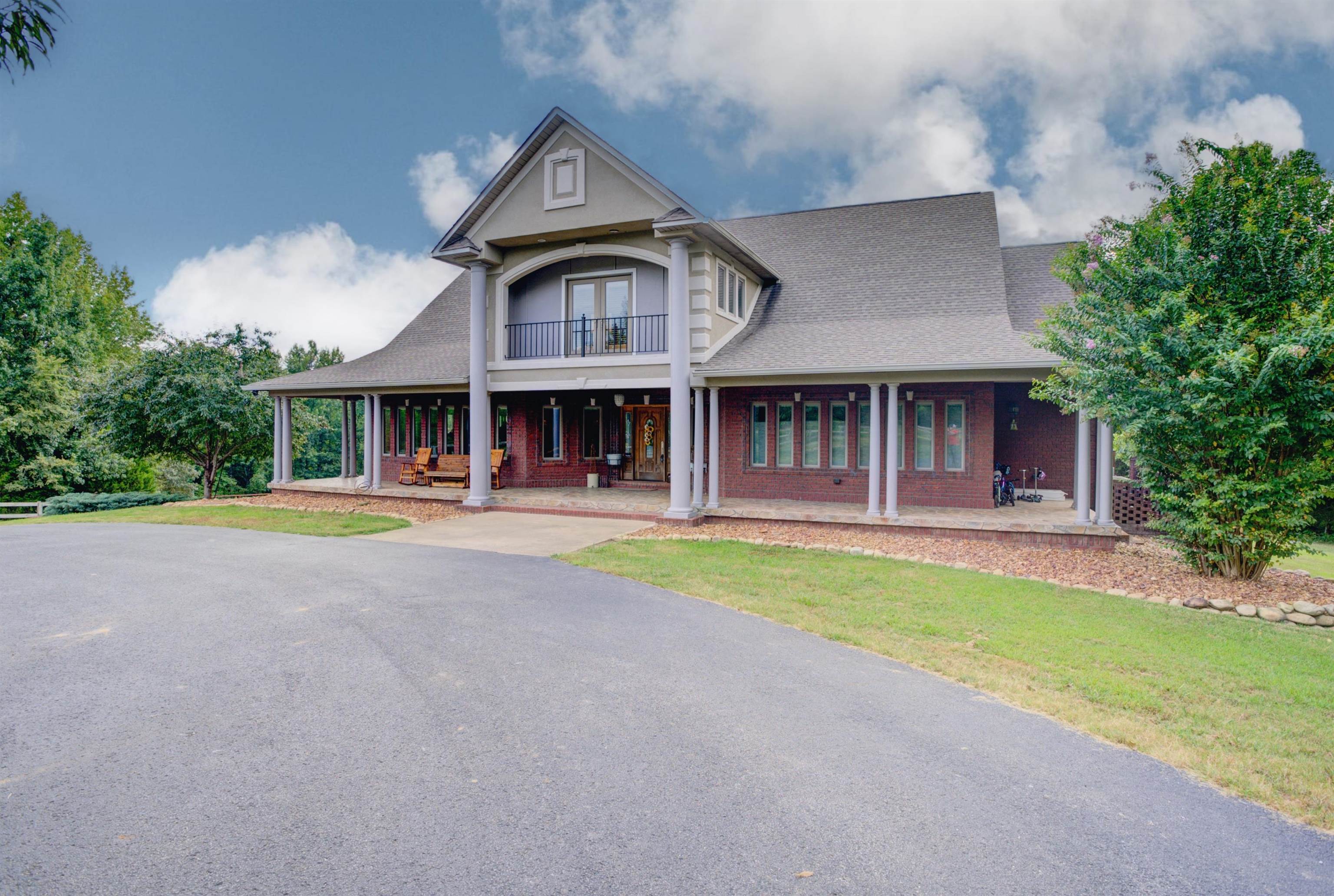 a front view of a house with yard and green space