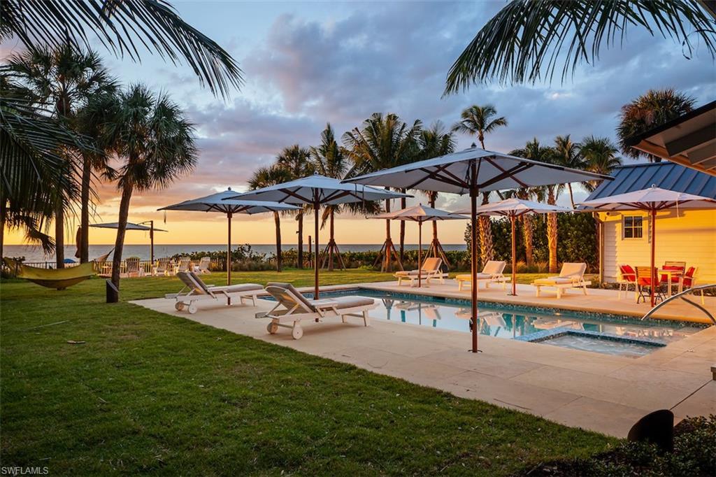 a view of a swimming pool with a table and chairs under an umbrella