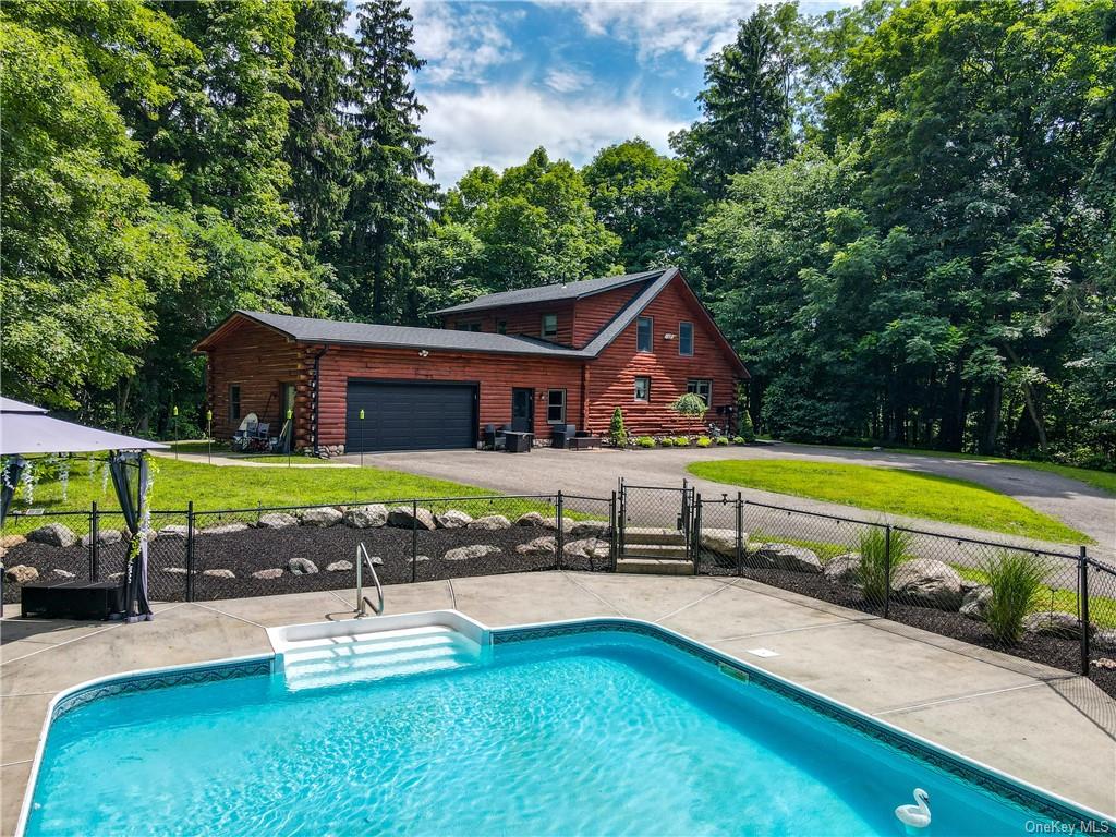 a view of a house with swimming pool and porch with furniture