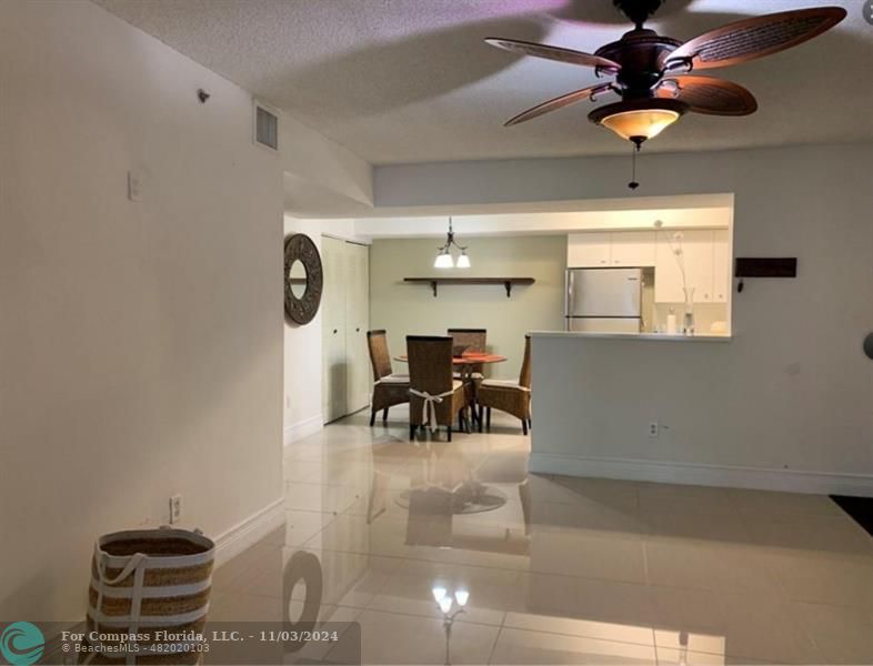 a dining room with furniture and a chandelier fan