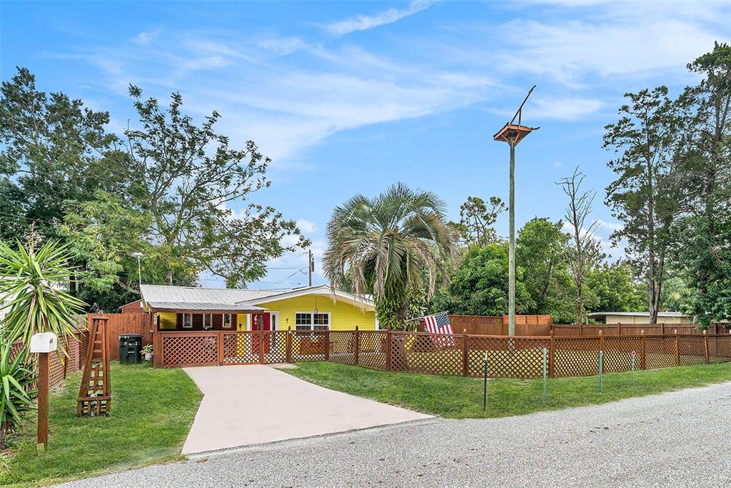 a front view of a house with a garden and tree