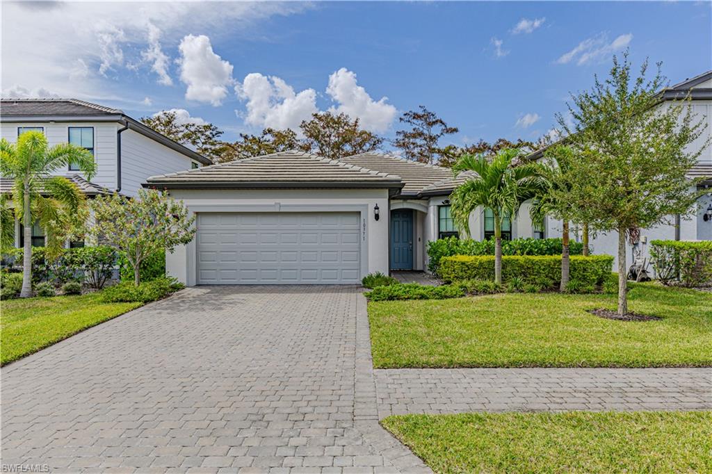 a front view of a house with a yard and a garage