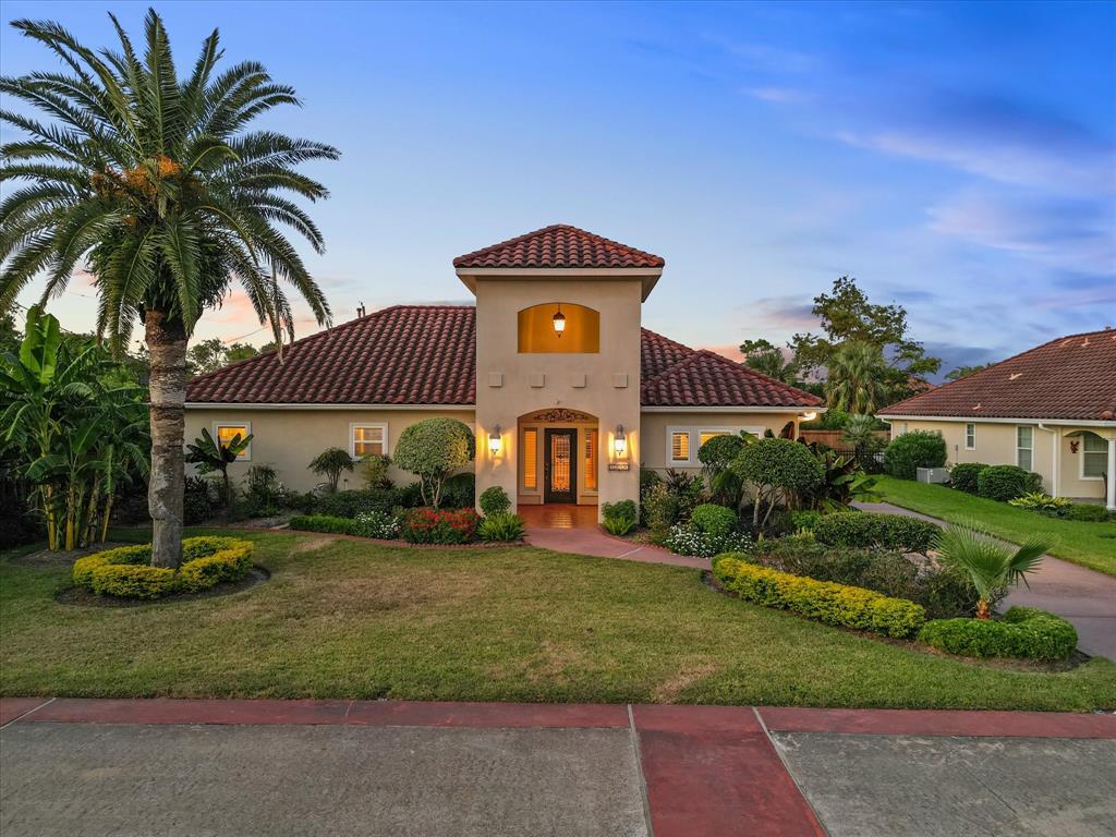 a front view of a house with a yard and potted plants