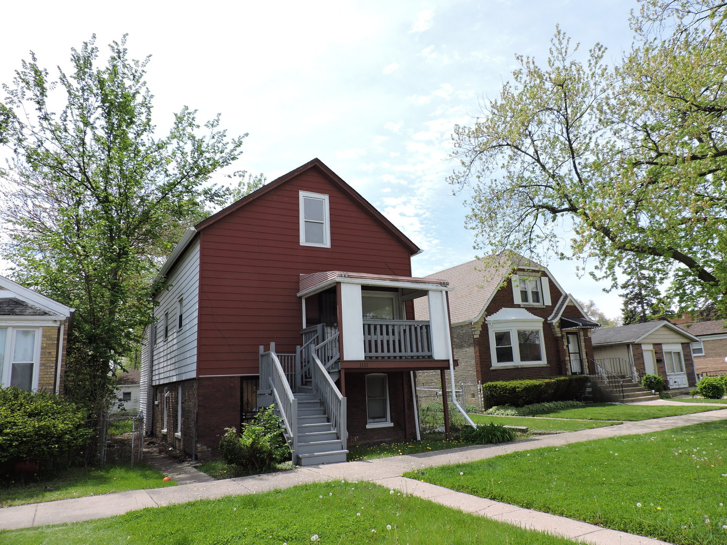 a front view of a house with a yard and trees