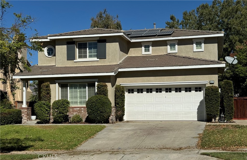 a front view of a house with a yard and a garage