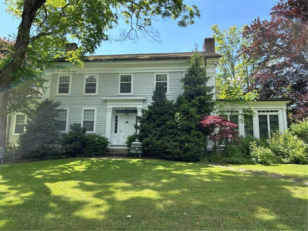 Colonial-style house featuring a front lawn