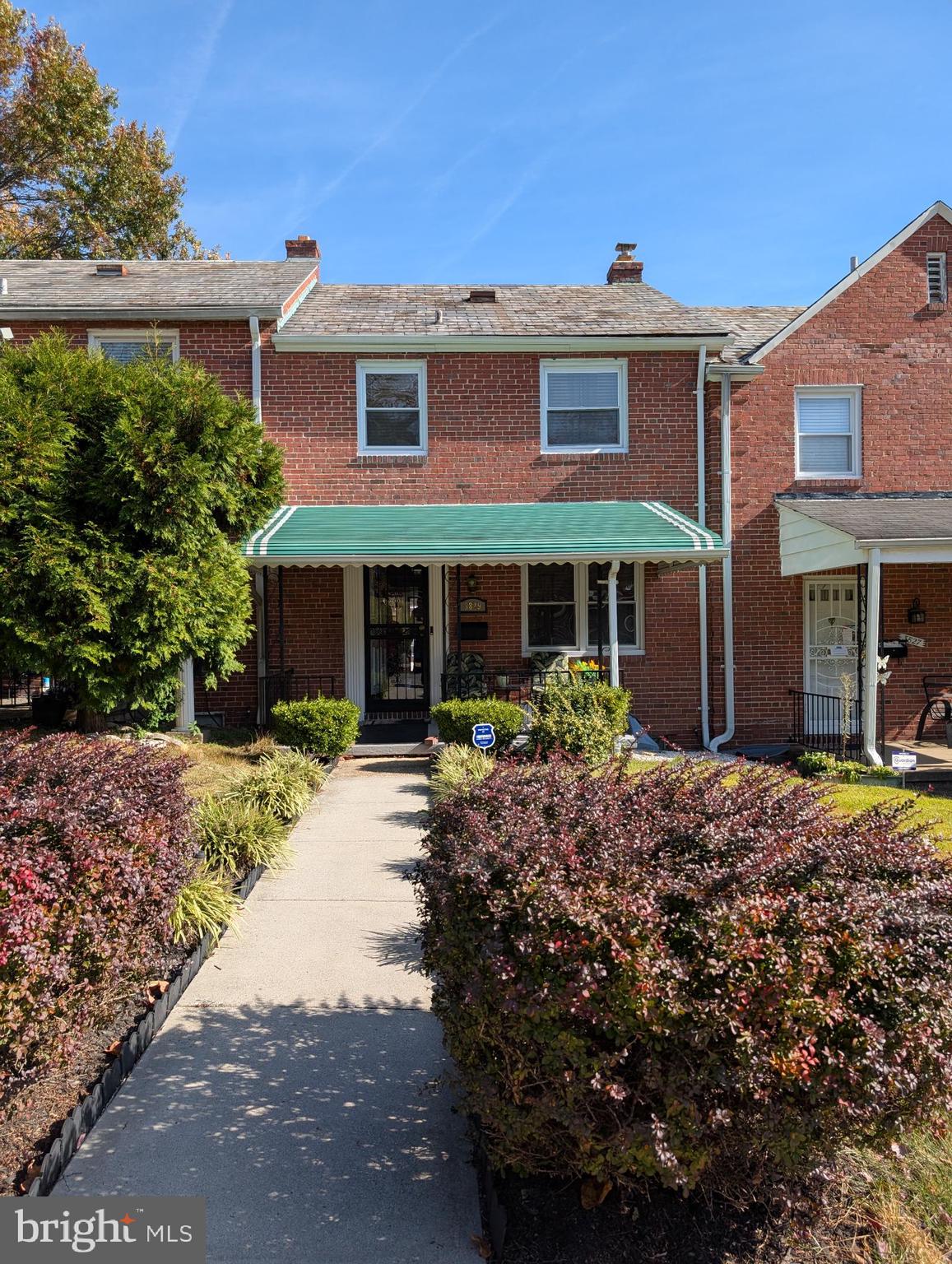 a front view of a house with a garden and yard