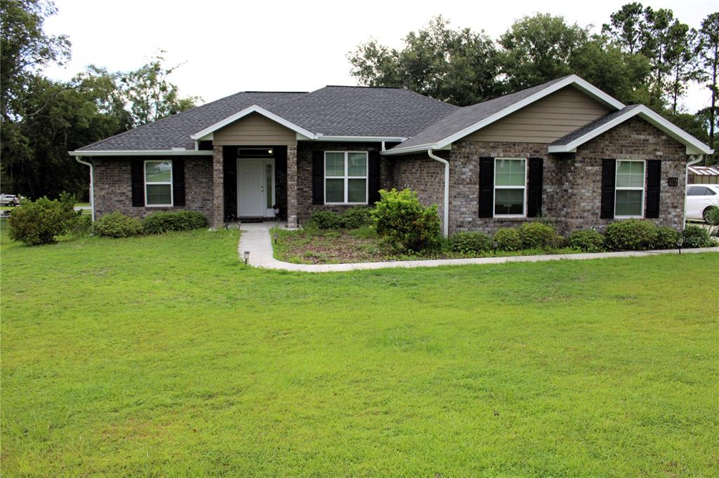 a front view of a house with a garden