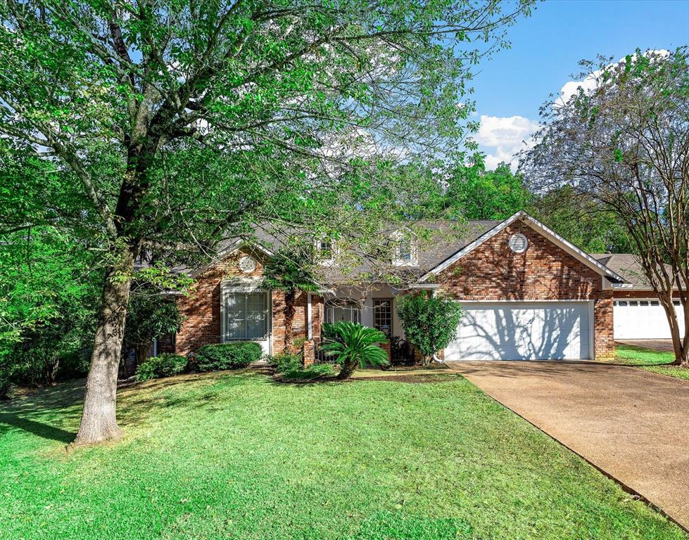 a front view of a house with a yard and trees