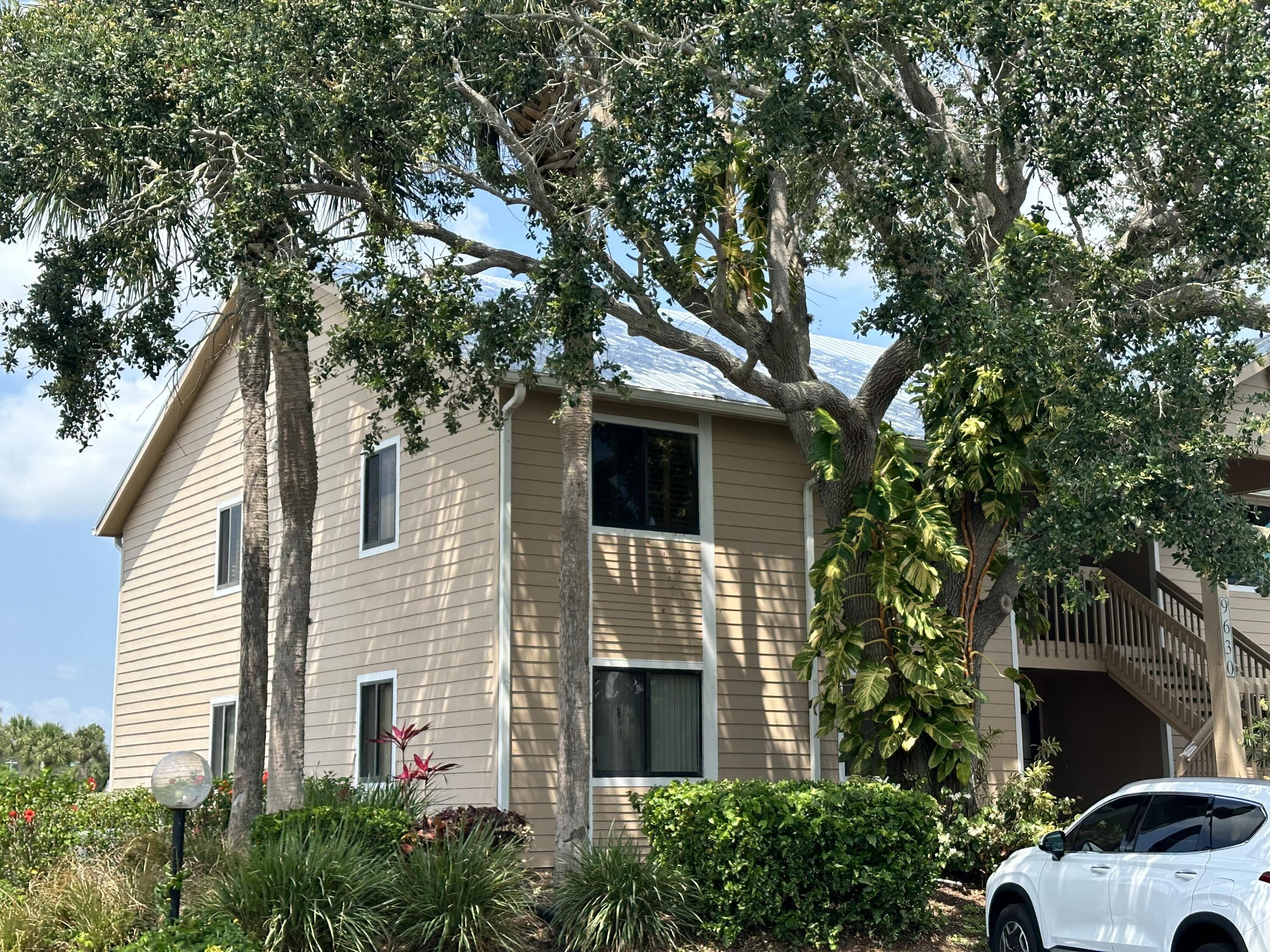 a front view of a house with a tree