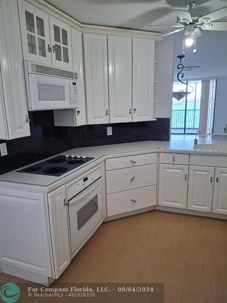 a kitchen with granite countertop white cabinets and sink