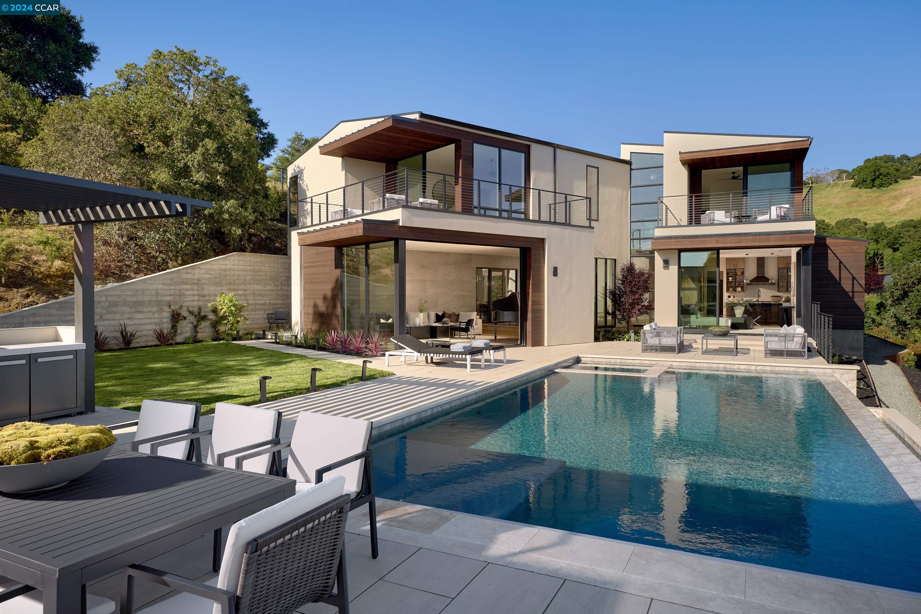 a view of a house with swimming pool and sitting area