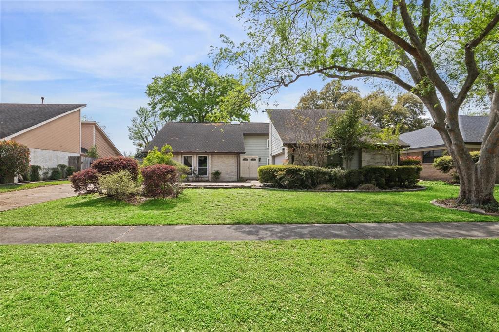 a front view of a house with a yard and trees