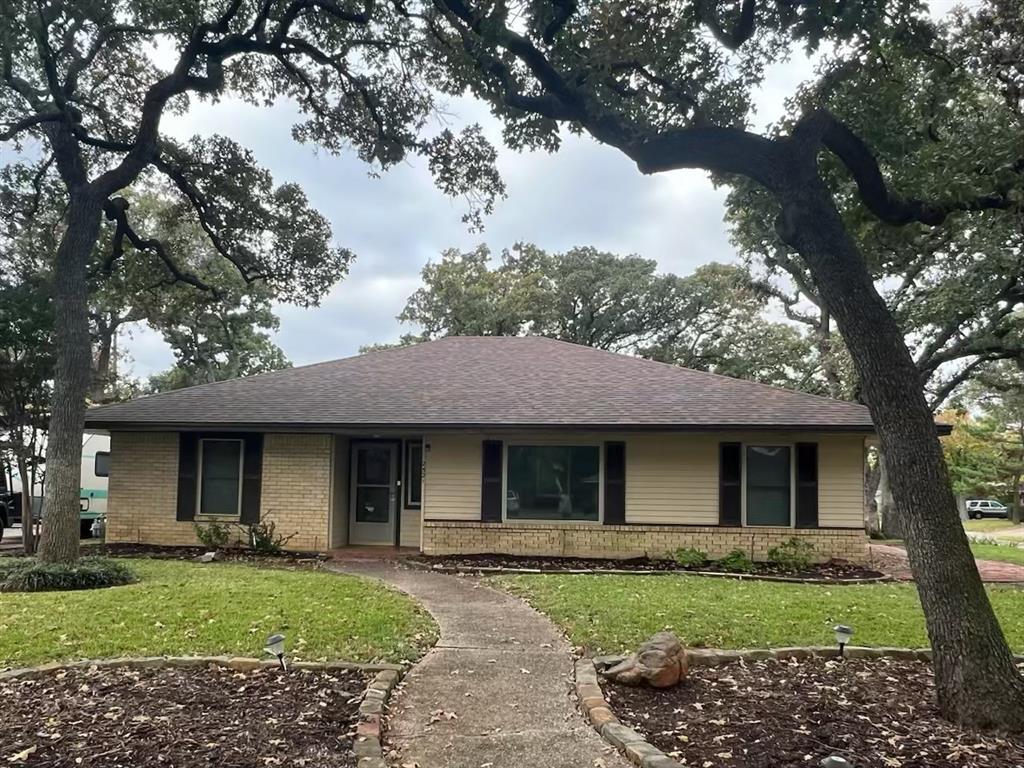 a front view of a house with a garden and trees