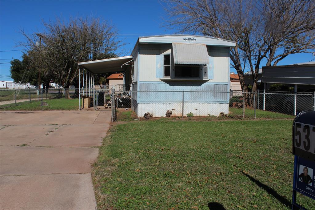 a view of a house with backyard and a tree