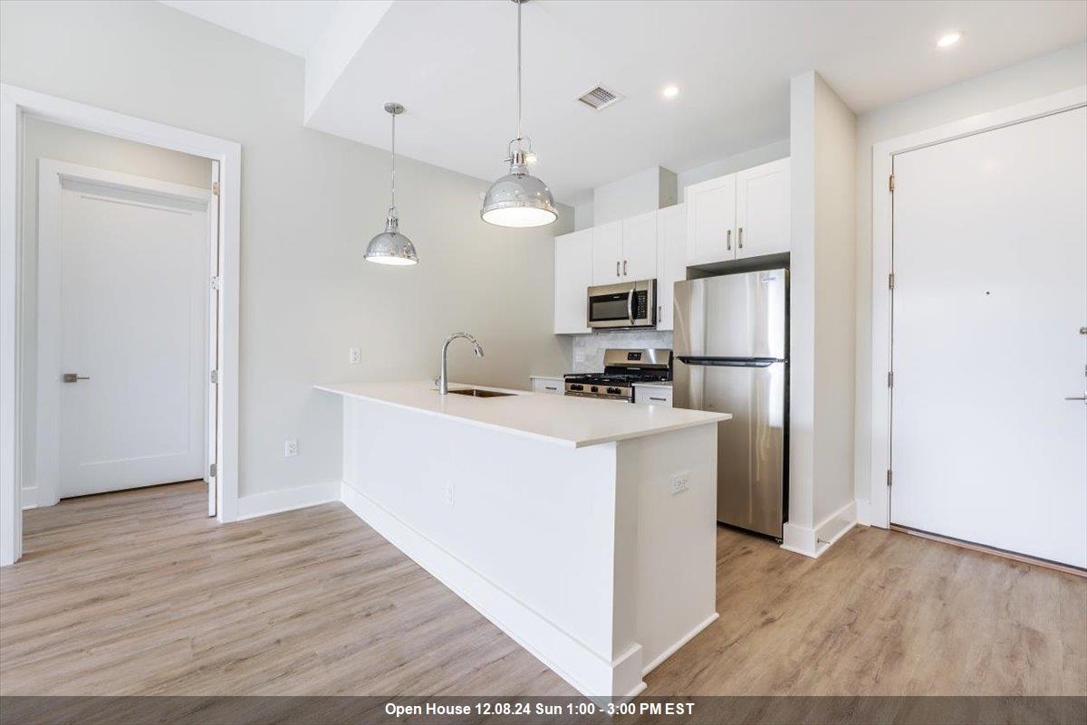 a kitchen with kitchen island a sink a refrigerator and a stove