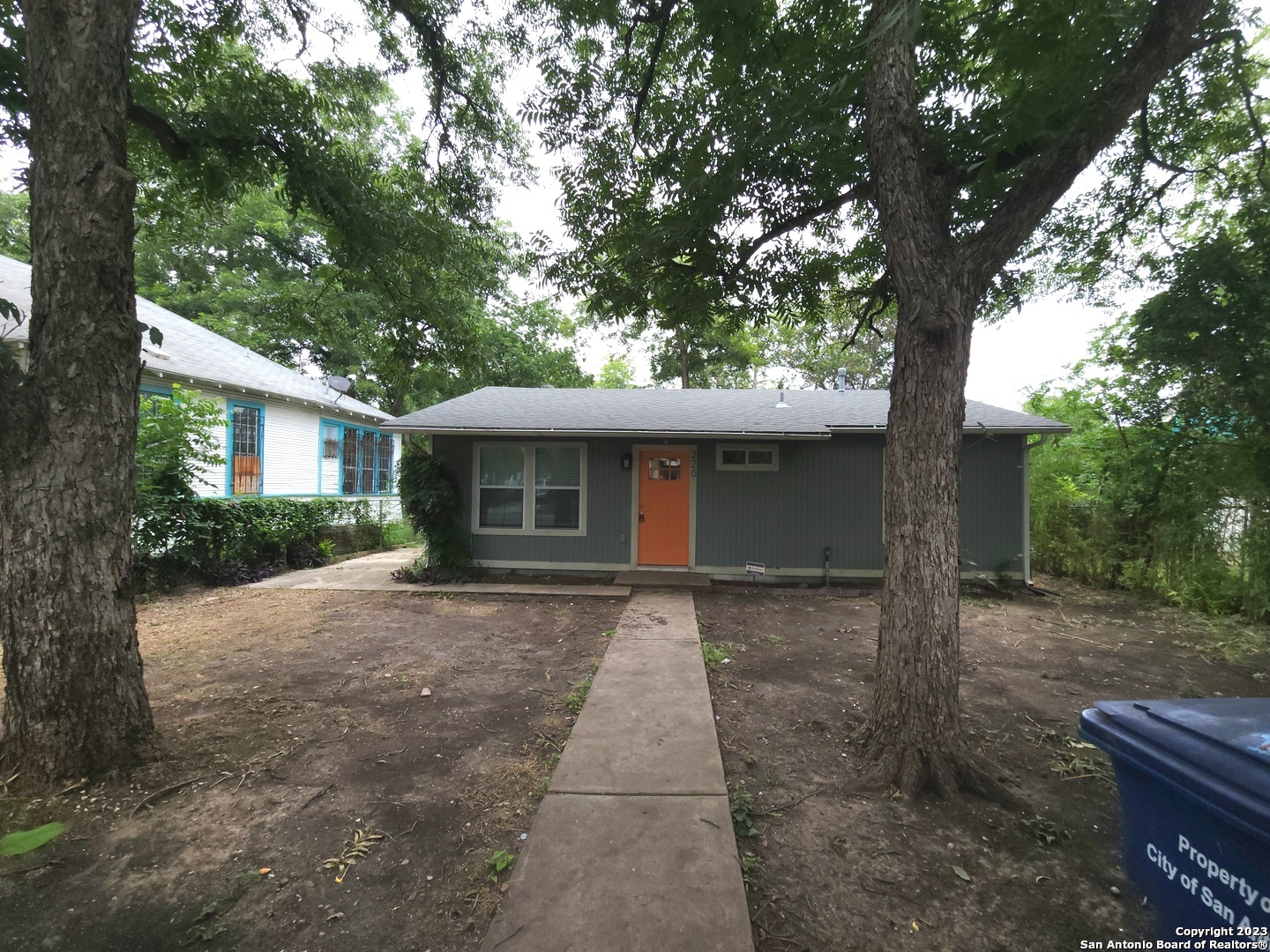 a front view of a house with a yard and trees