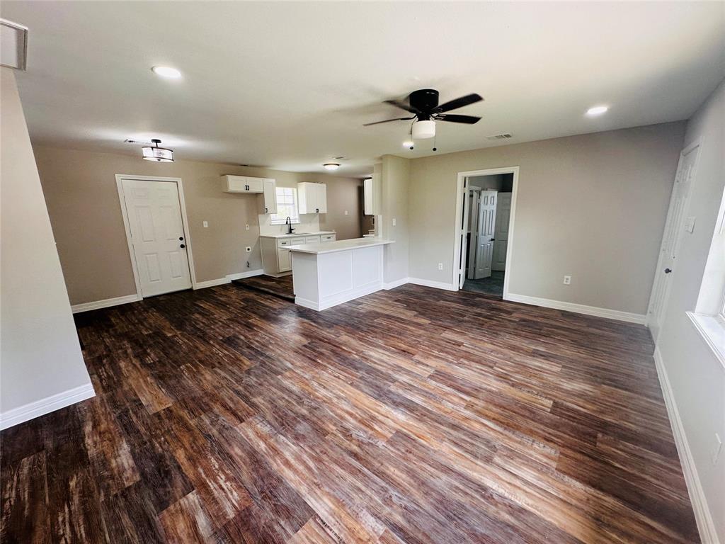 a view of a livingroom with a hall and wooden floor