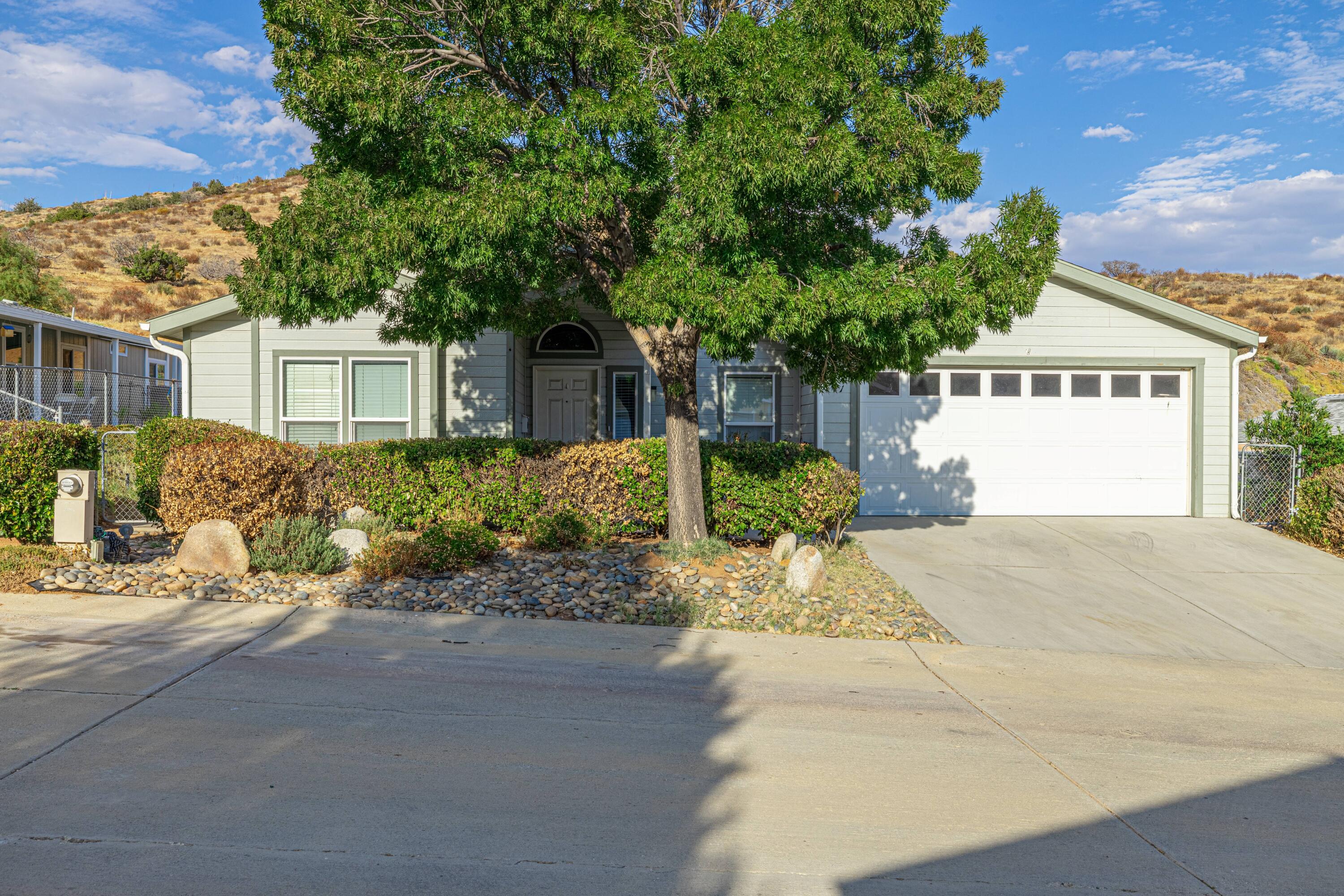 a view of a house with a yard and potted plants