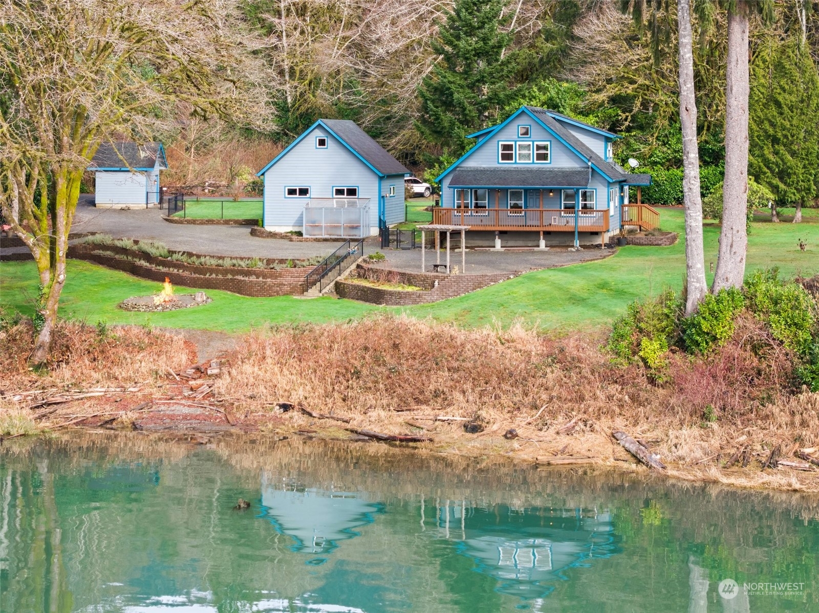 a front view of a house with a yard and lake view