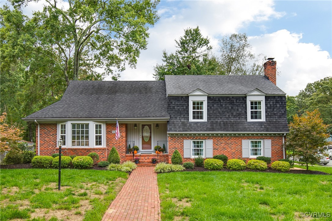 a front view of a house with a garden and yard