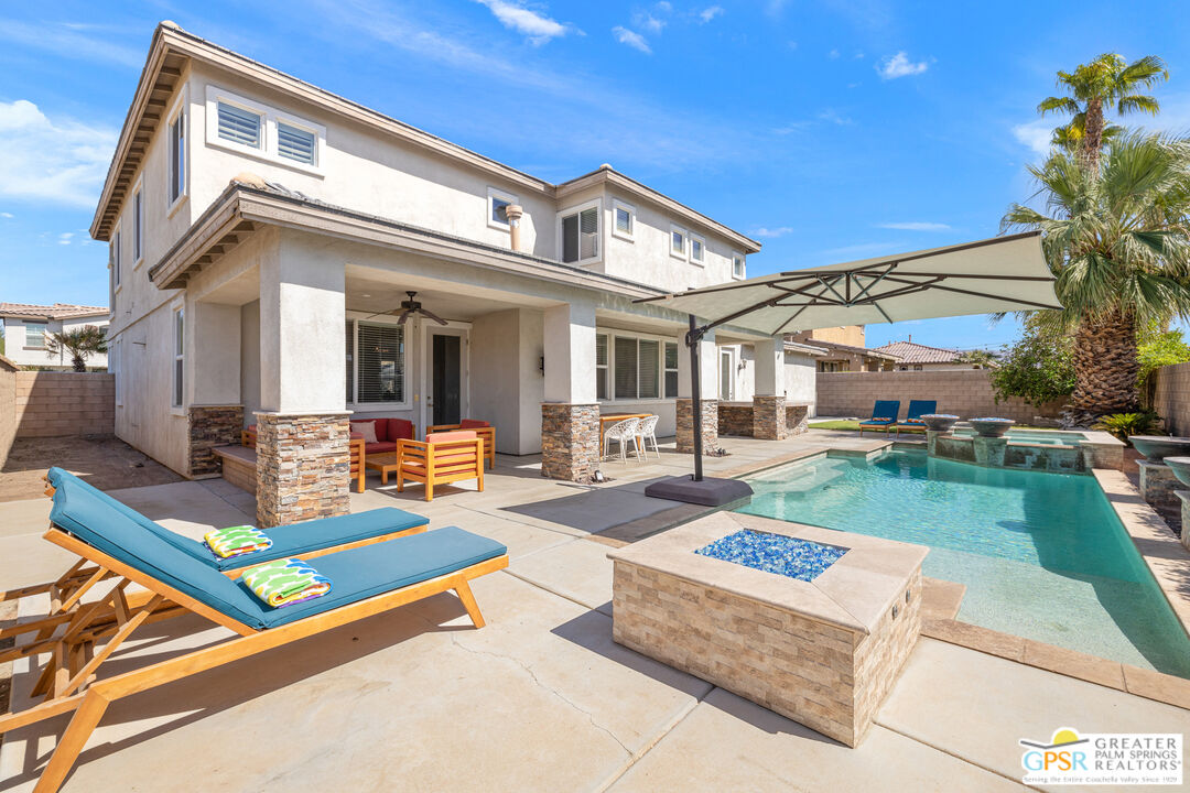 a front view of a house with swimming pool outdoor seating