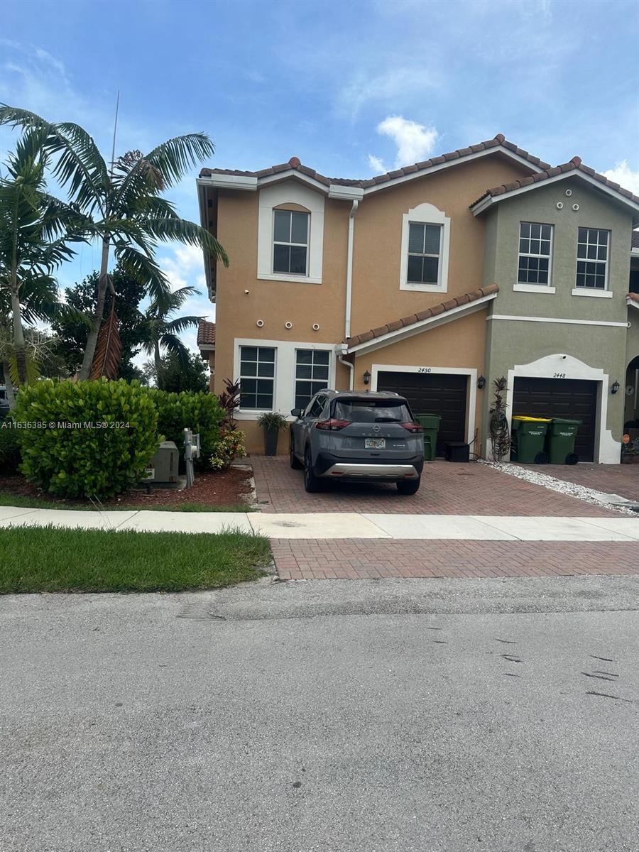 a front view of a house with a yard and a garage