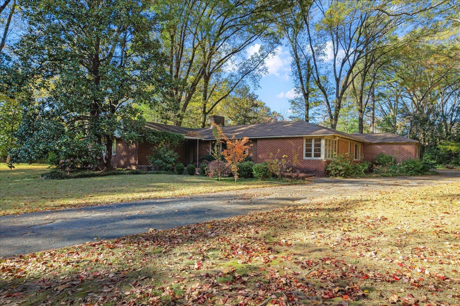 a front view of a house with a yard and trees