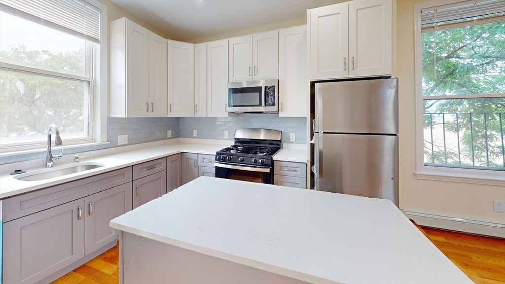 a kitchen with white cabinets and white appliances