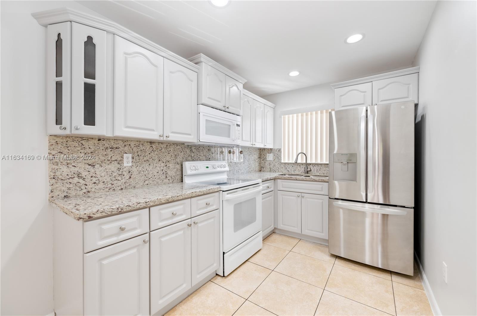 a kitchen with stainless steel appliances granite countertop a refrigerator sink and cabinets