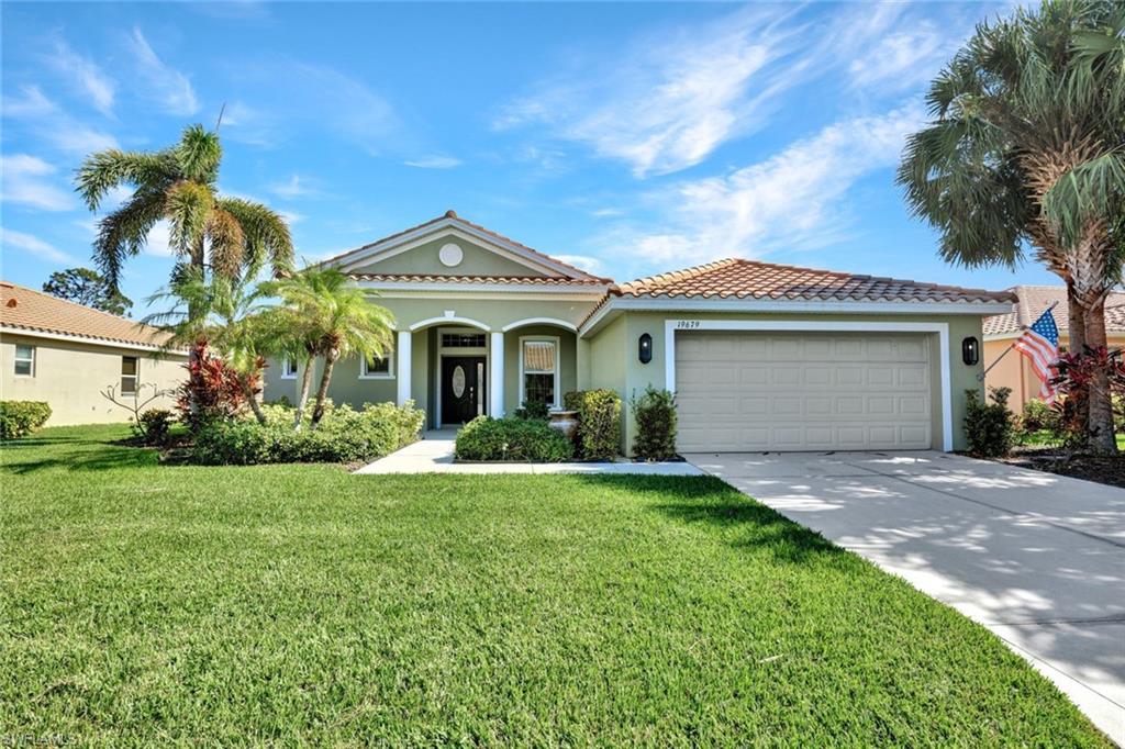 View of front of home with a front yard and a garage