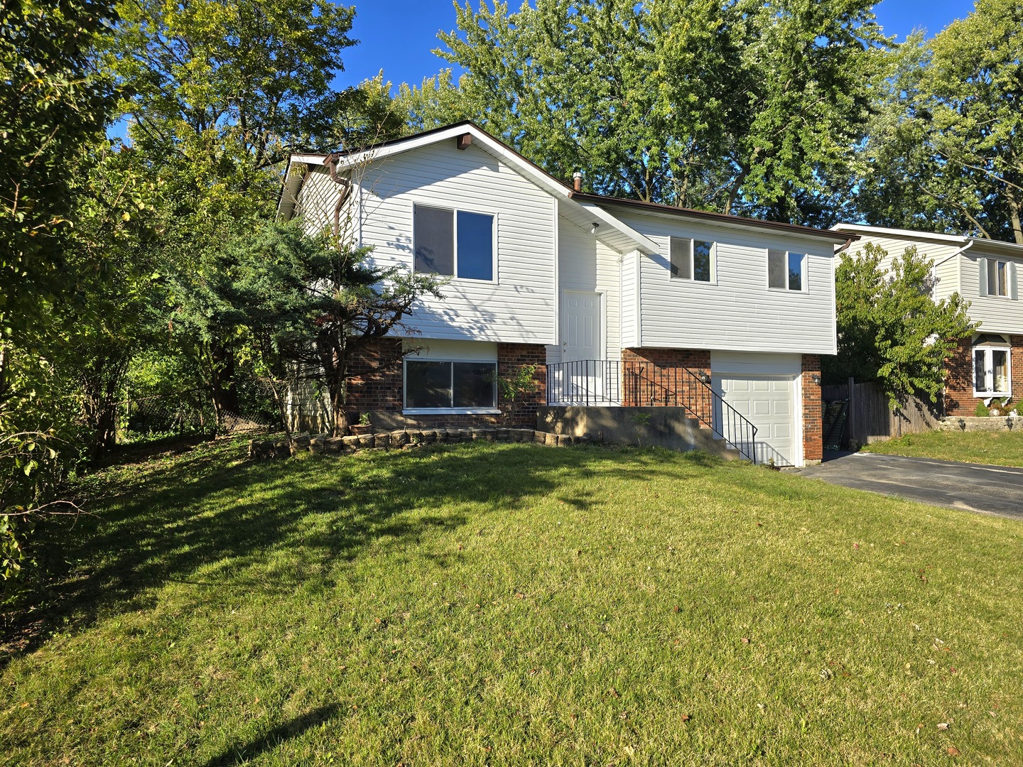 a front view of a house with a garden and yard