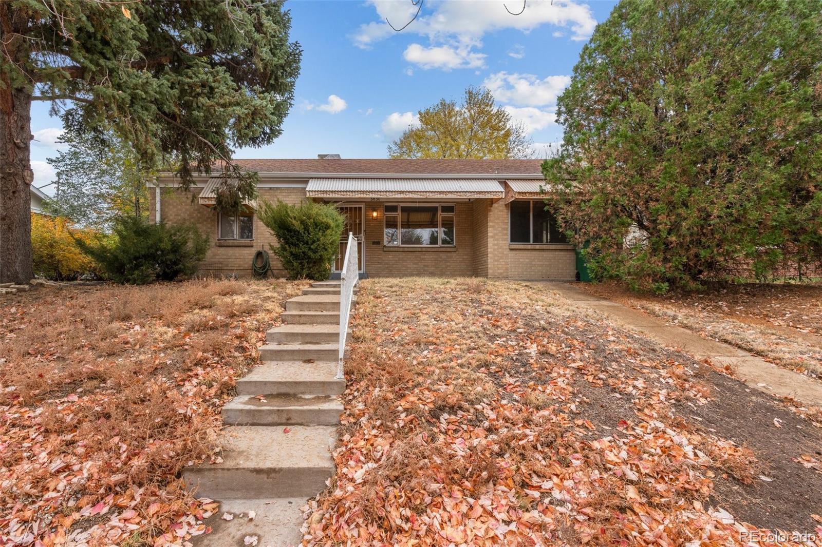 a front view of house with yard and trees around