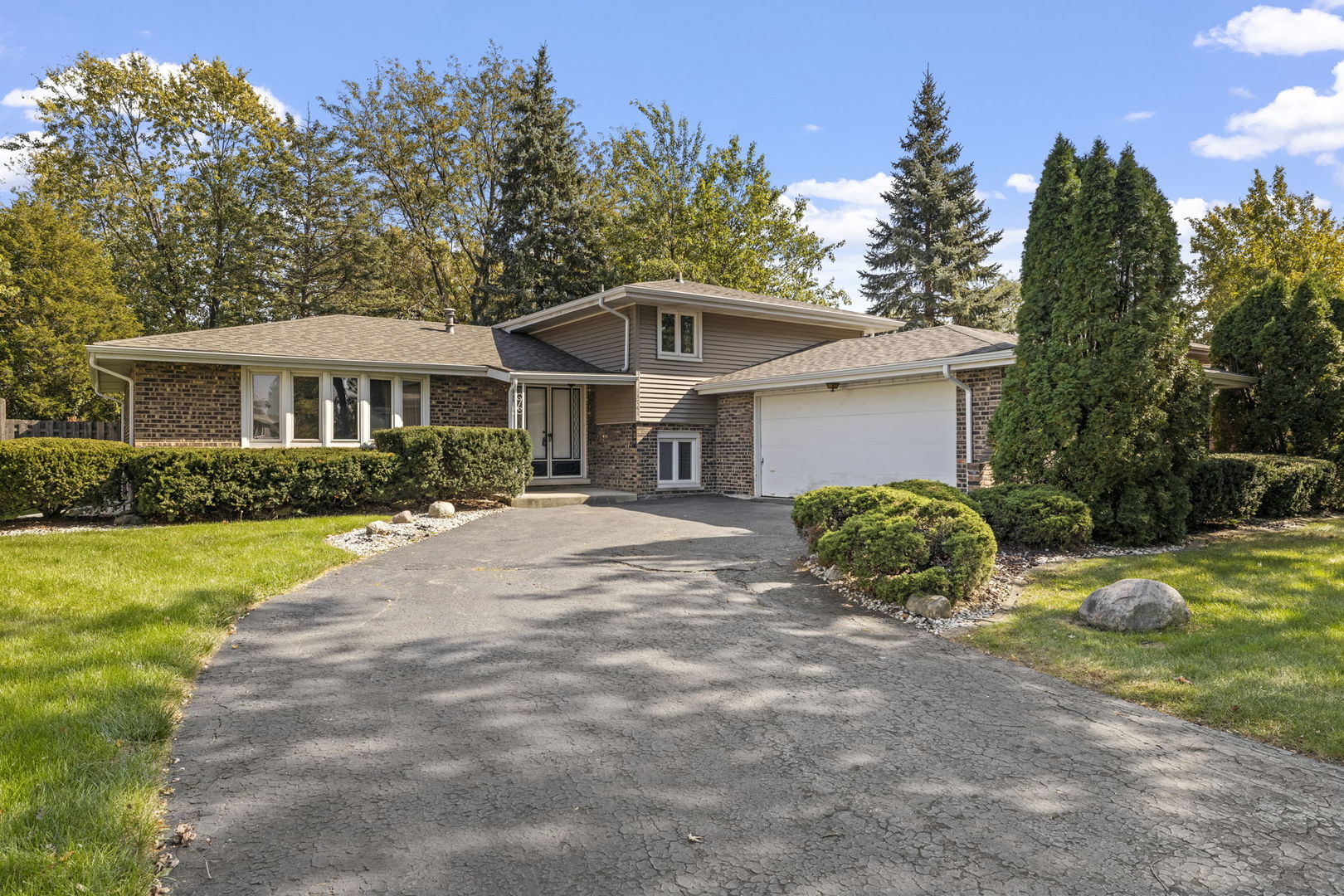 a front view of a house with a yard and trees