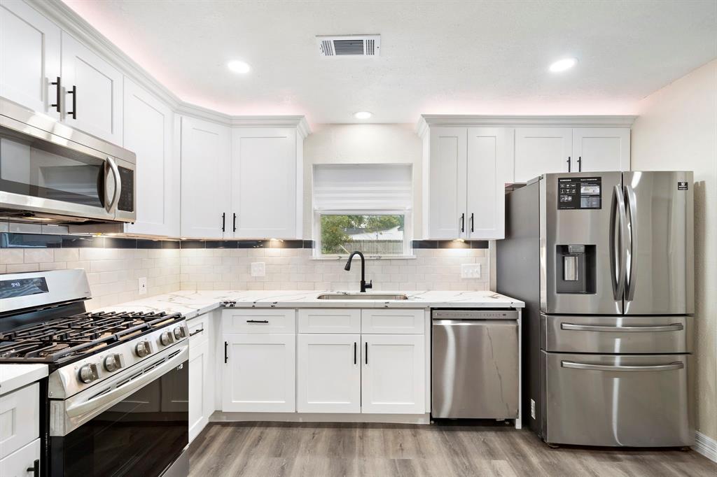 a kitchen with appliances a sink and a counter top space