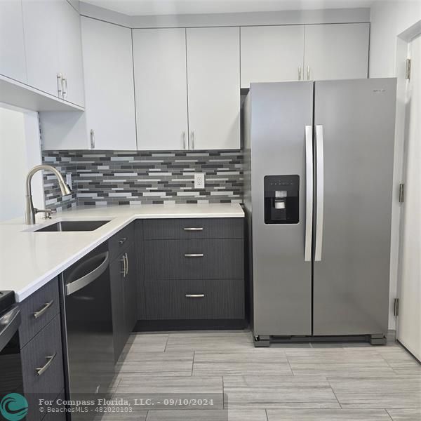 a kitchen with a sink cabinets and stainless steel appliances