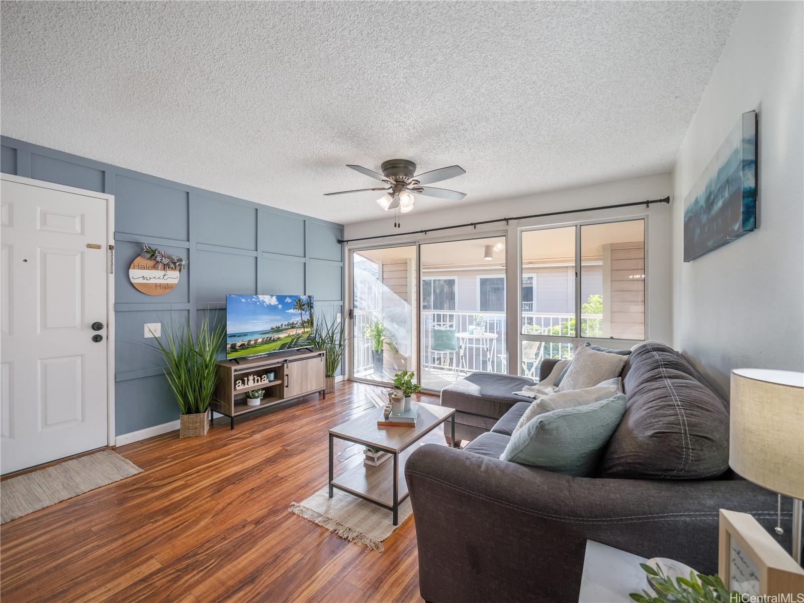 a living room with furniture floor to ceiling window and wooden floor