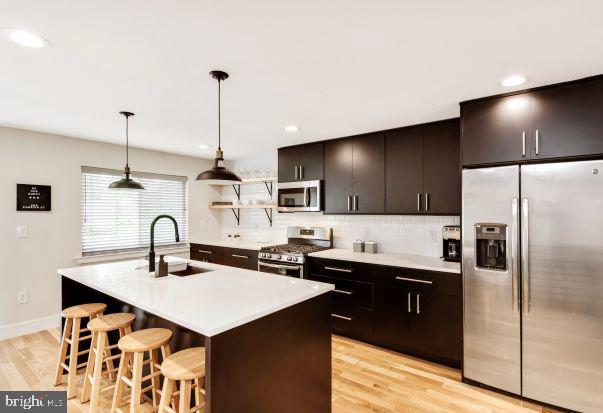 a kitchen with a sink a counter top space stainless steel appliances and cabinets