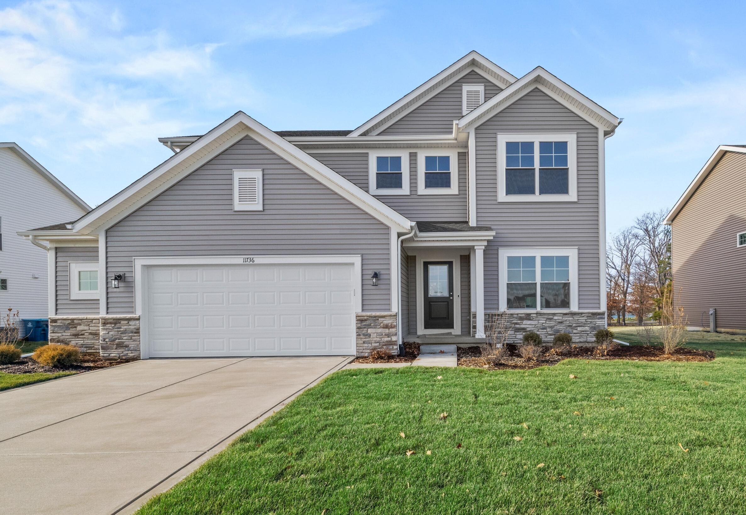 a front view of house with yard and green space