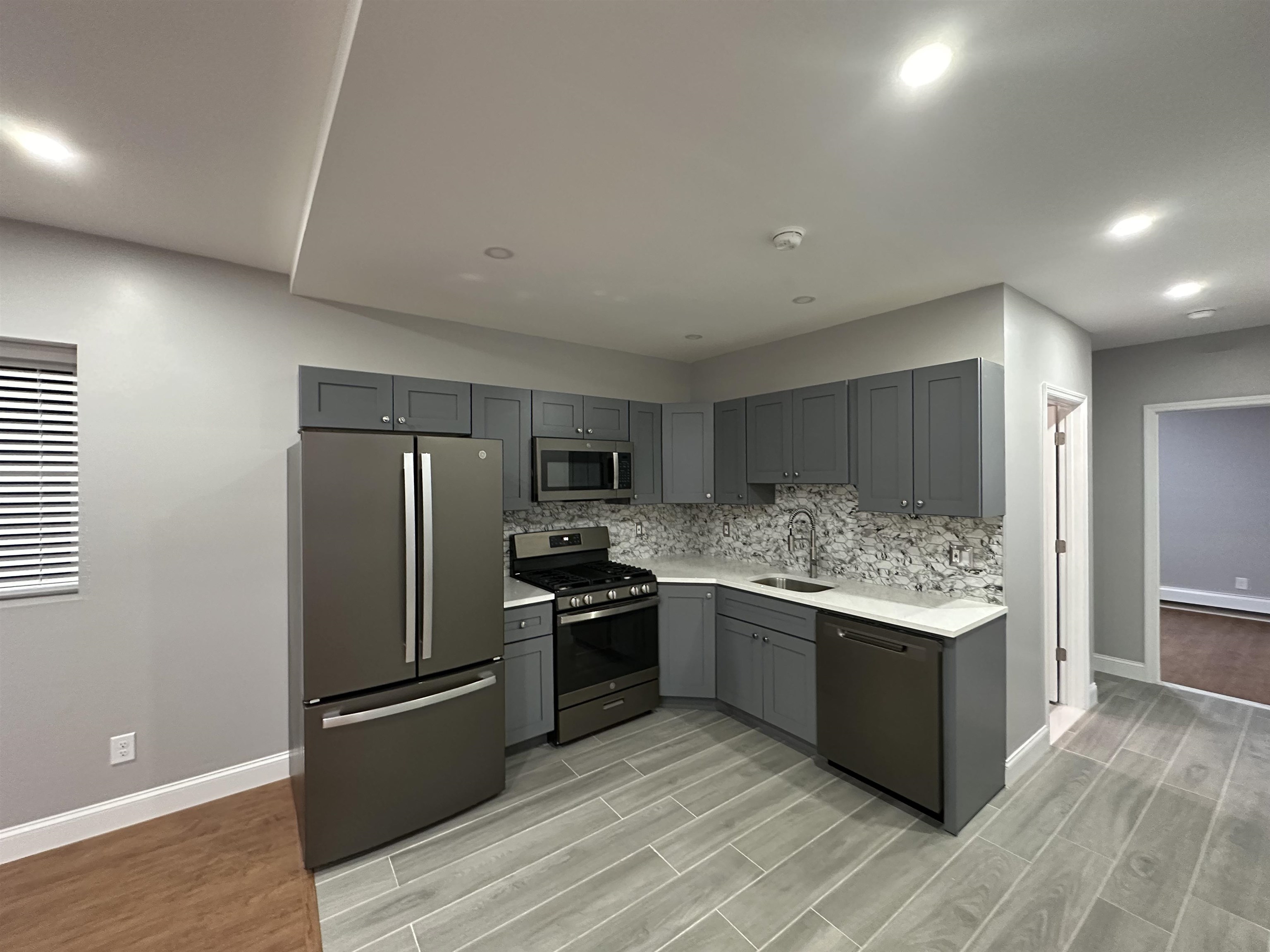 a kitchen with stainless steel appliances granite countertop a refrigerator and a stove